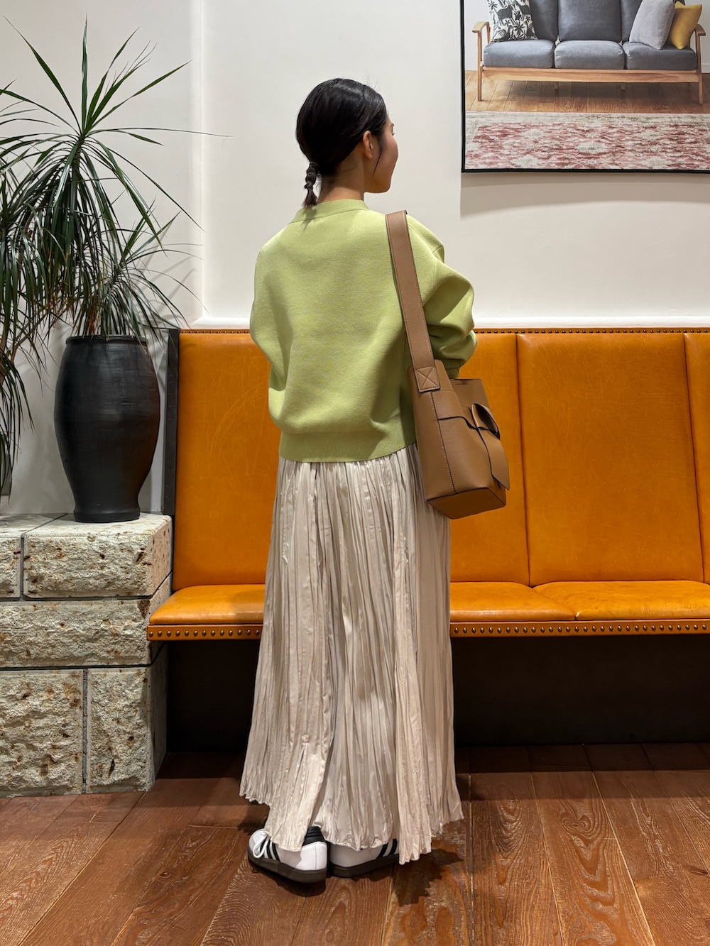 ホワイト系のスニーカー、グリーン系のカーディガン/ボレロ、ホワイト系のスカートを着用したレディースの冬コーディネートの3枚目の写真