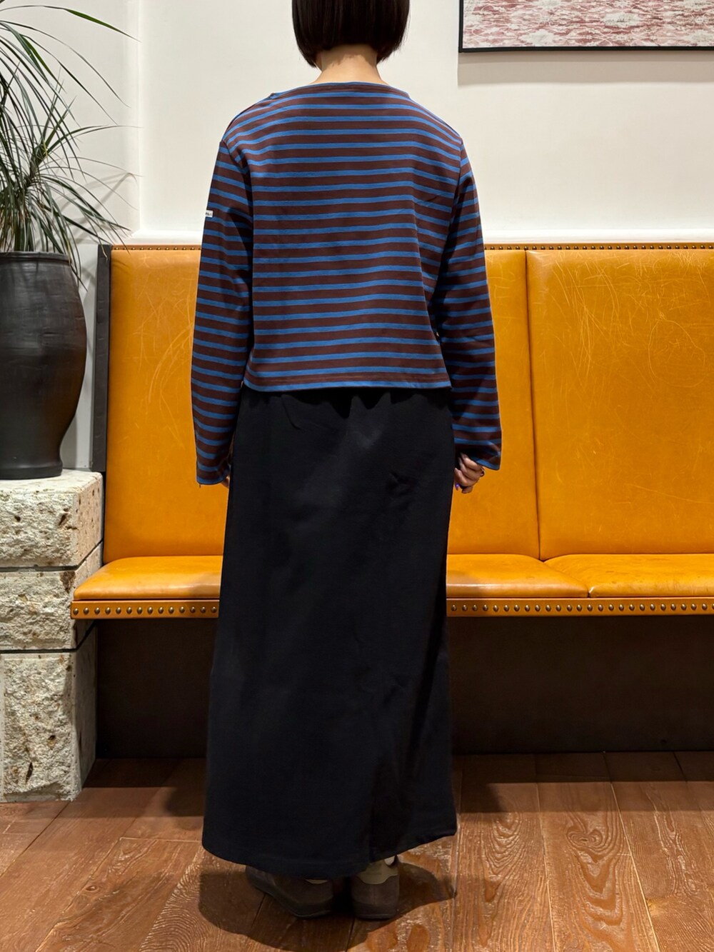 ブラック系のスカート、ブラウン系のTシャツ/カットソー、ブラック系のバックパック/リュックを着用したレディースの秋コーディネートの3枚目の写真