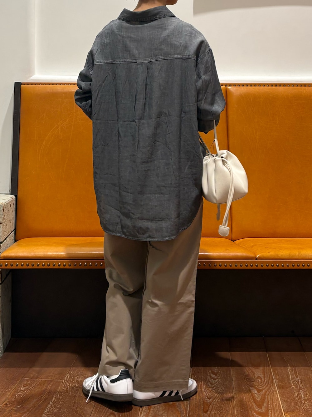 ホワイト系のショルダーバッグ、ホワイト系のスニーカー、ブラック系のシャツ/ブラウスを着用したレディースの春コーディネートの2枚目の写真