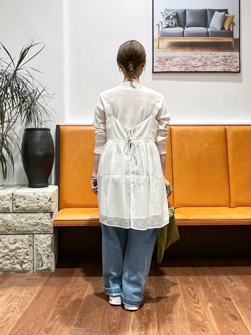 ブルー系のデニムパンツ、ホワイト系のTシャツ/カットソー、ゴールド系のトートバッグを着用したレディースの夏コーディネートの3枚目の写真