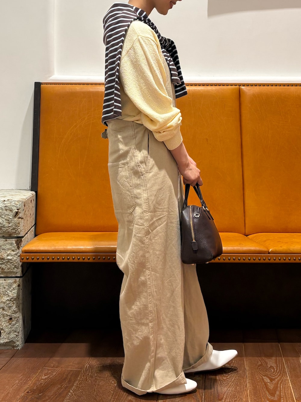 ブルー系のTシャツ/カットソー、ホワイト系のその他シューズ、ベージュ系のニット/セーターを着用したレディースの春コーディネートの2枚目の写真