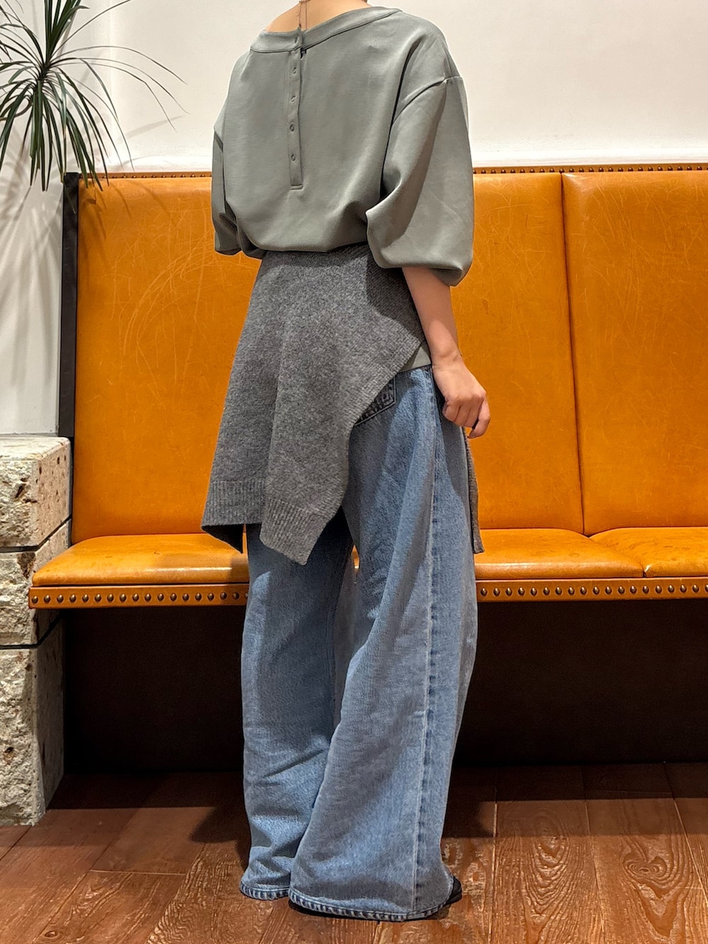 グリーン系のTシャツ/カットソー、ブルー系のデニムパンツ、グレー系のストール/ショールを着用したレディースの秋コーディネートの2枚目の写真