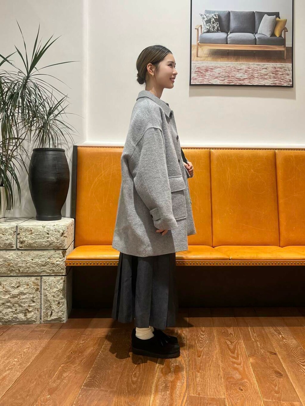 グレー系のその他アウター、ホワイト系のTシャツ/カットソー、ブラック系のブーツを着用したレディースの秋コーディネートの2枚目の写真