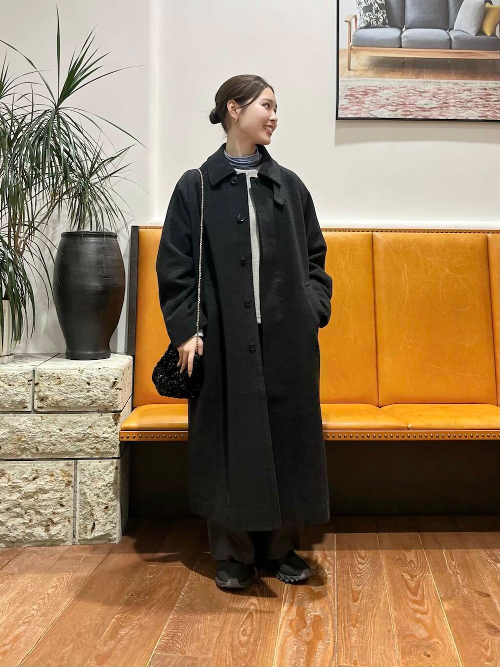 ブラック系のショルダーバッグ、グレー系のその他アウター、ブルー系のTシャツ/カットソーを着用したレディースの冬コーディネートの2枚目の写真