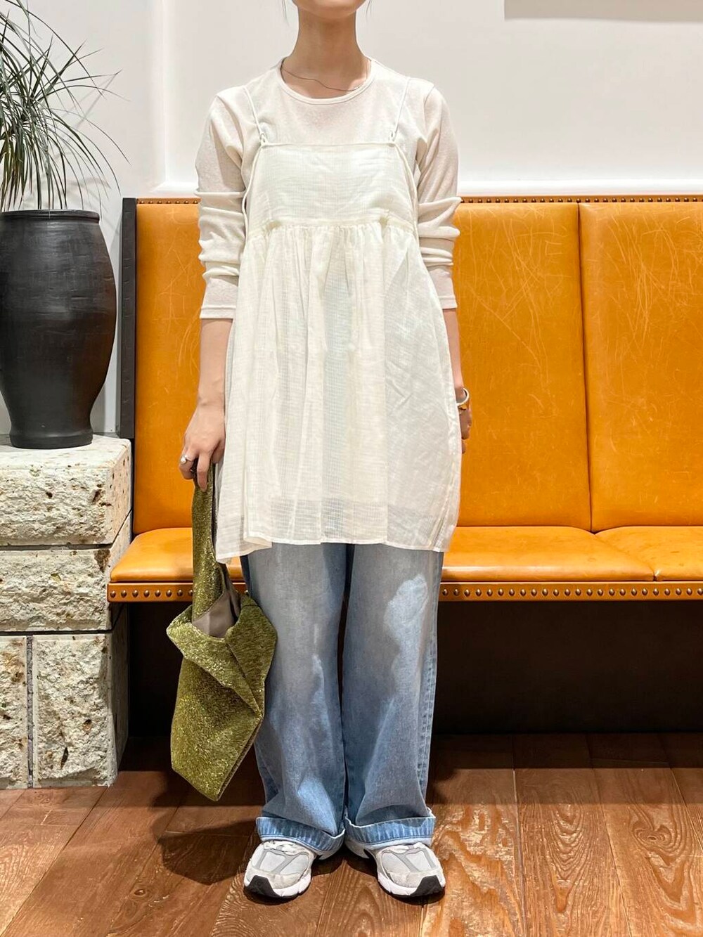 ブルー系のデニムパンツ、ホワイト系のTシャツ/カットソー、ゴールド系のトートバッグを着用したレディースの夏コーディネートの2枚目の写真