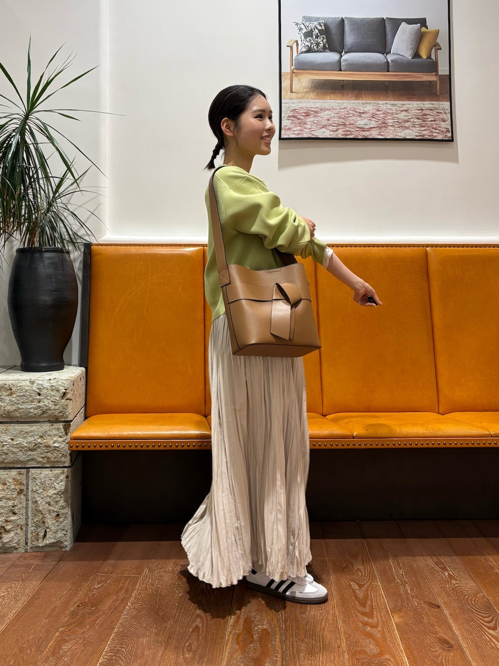 ホワイト系のスニーカー、グリーン系のカーディガン/ボレロ、ホワイト系のスカートを着用したレディースの冬コーディネートの2枚目の写真