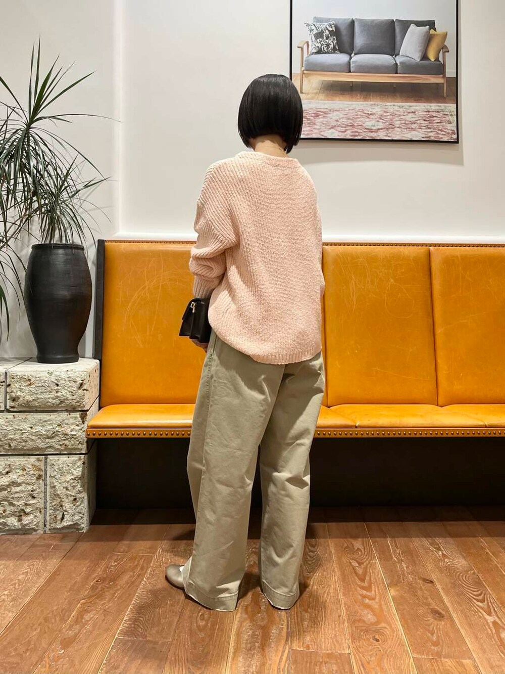 ゴールド系のパンプス、ブラウン系のショルダーバッグ、ピンク系のニット/セーターを着用したレディースの冬コーディネートの2枚目の写真