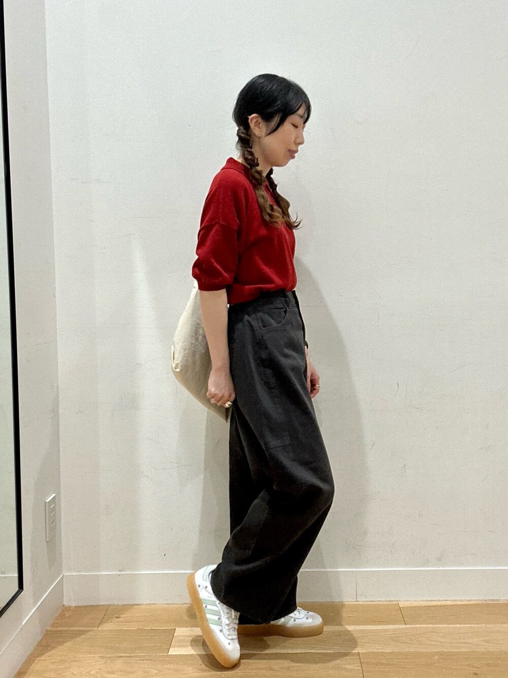 レッド系のニット/セーター、ホワイト系のショルダーバッグ、ブラック系のパンツを着用したレディースの夏コーディネートの5枚目の写真