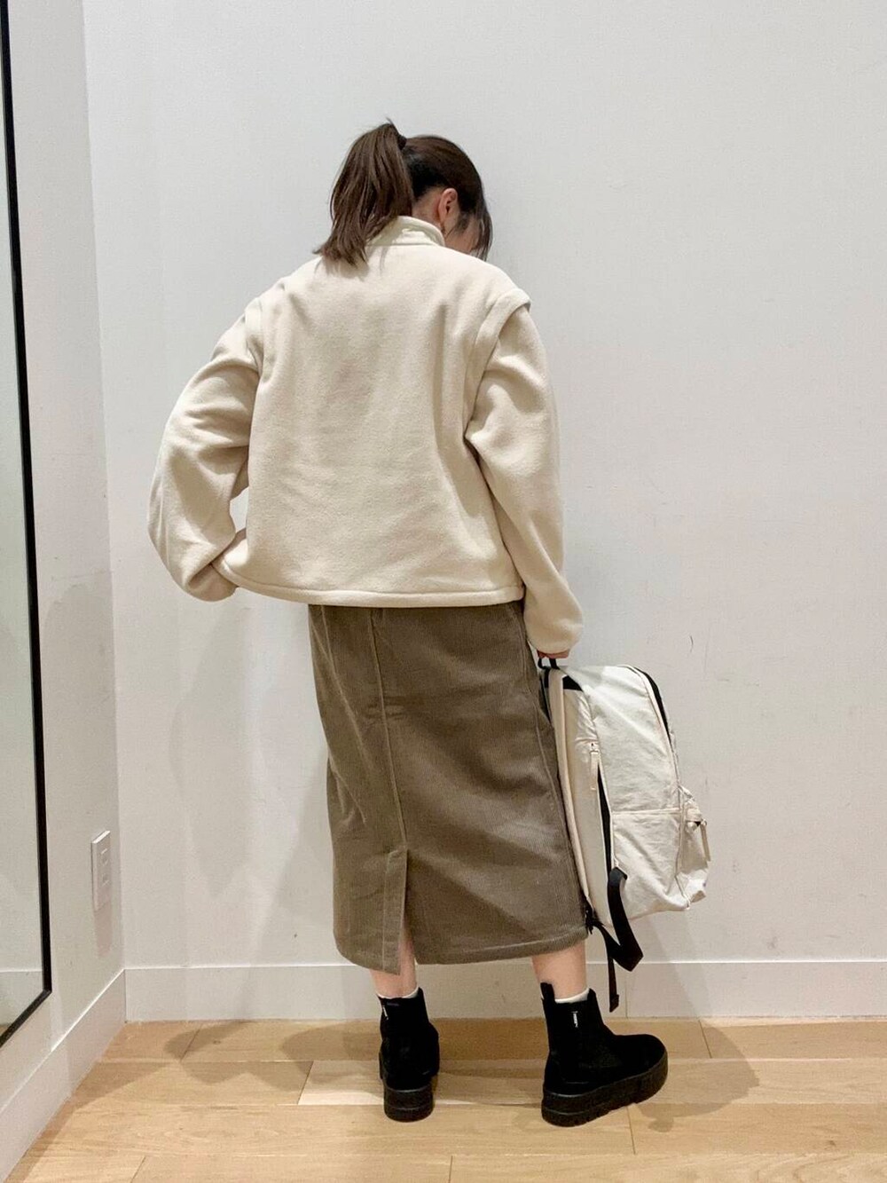 ホワイト系のバックパック/リュック、ブラウン系のスカート、ホワイト系のTシャツ/カットソーを着用したレディースの秋コーディネートの3枚目の写真