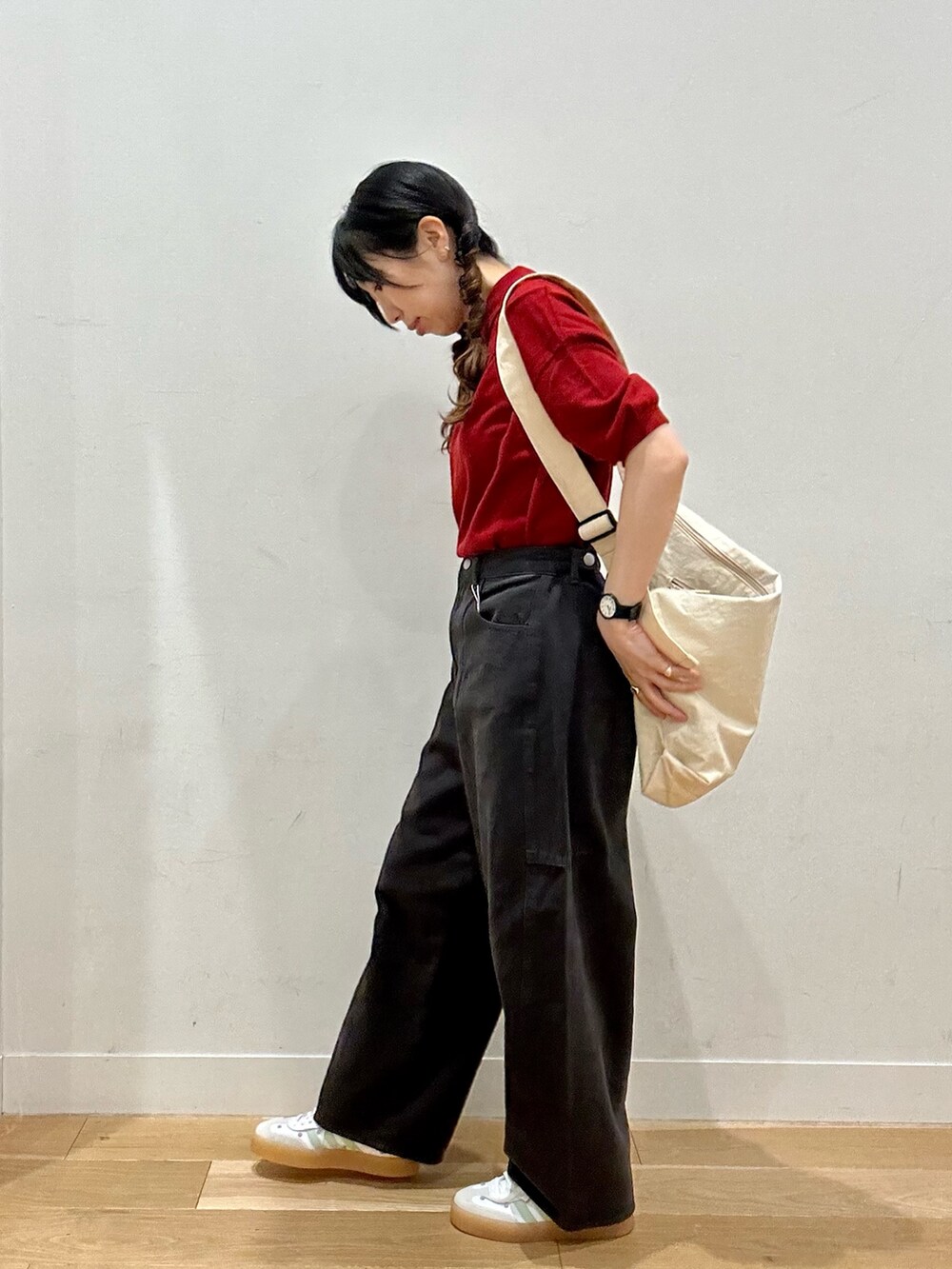 レッド系のニット/セーター、ホワイト系のショルダーバッグ、ブラック系のパンツを着用したレディースの夏コーディネートの2枚目の写真