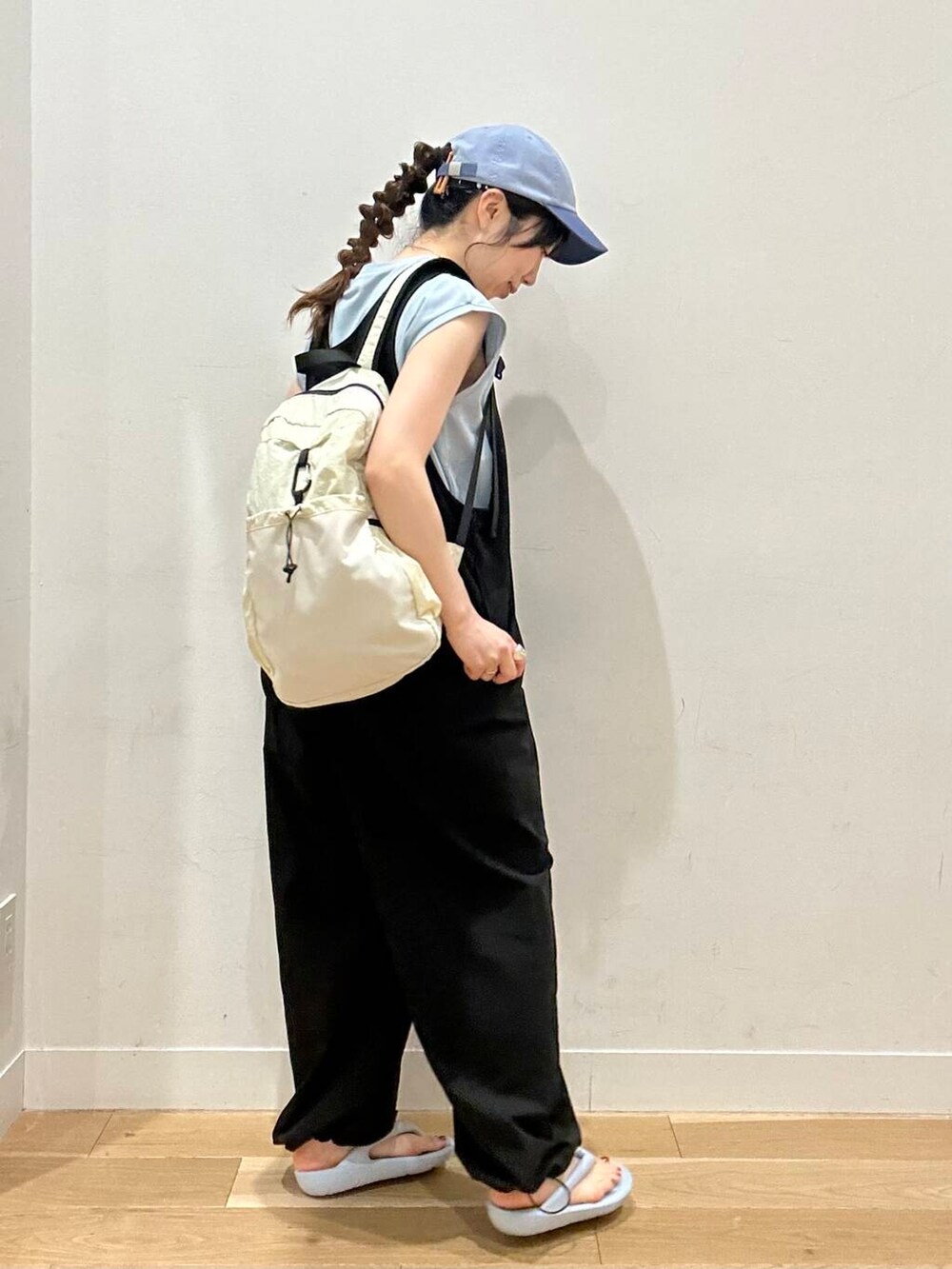 ブラック系のワンピース、ホワイト系のバックパック/リュック、ブルー系のサンダルを着用したレディースの夏コーディネートの4枚目の写真