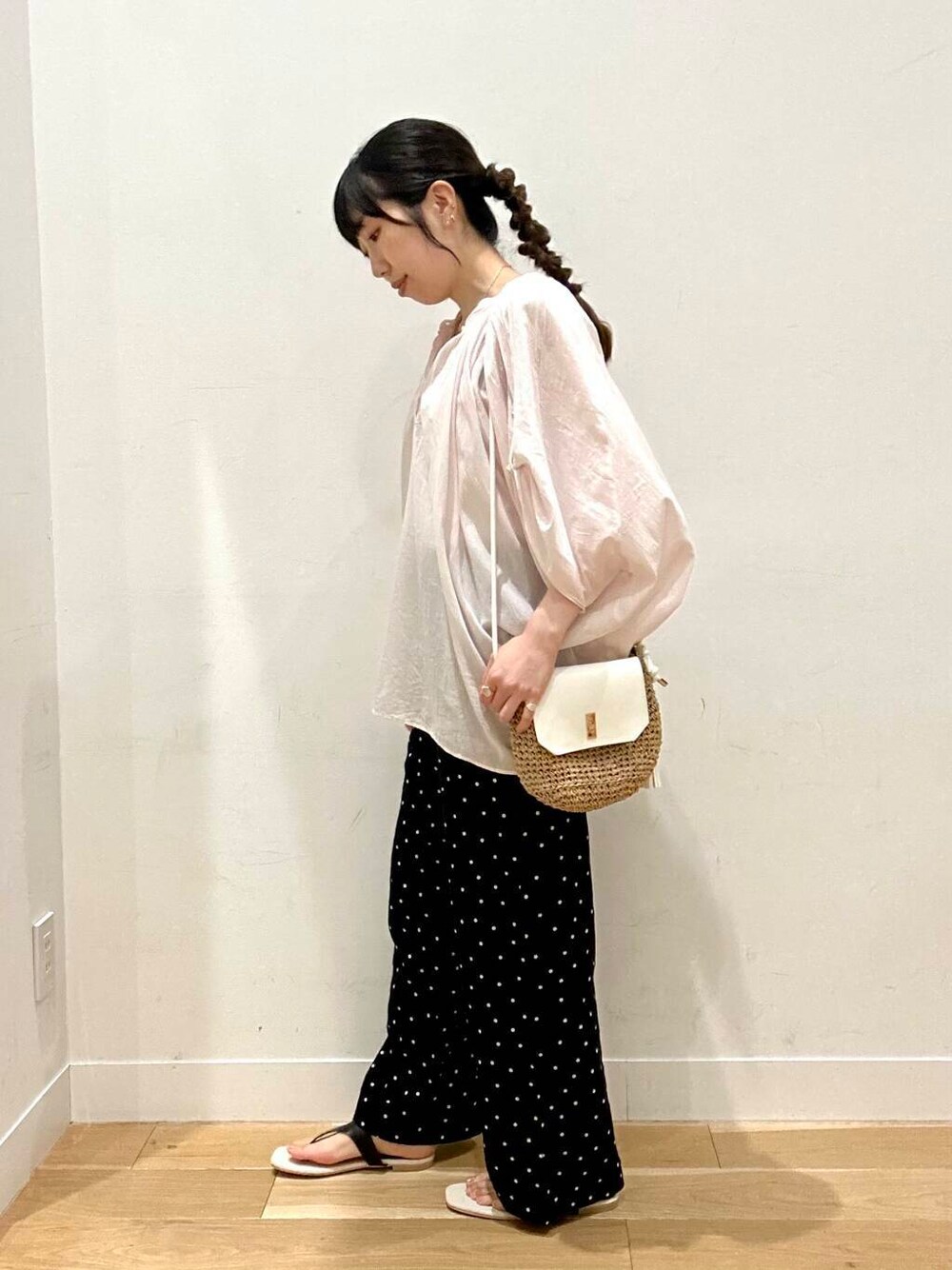 イエロー系のショルダーバッグ、ホワイト系のタンクトップ、ブラック系のその他パンツを着用したレディースの夏コーディネートの3枚目の写真