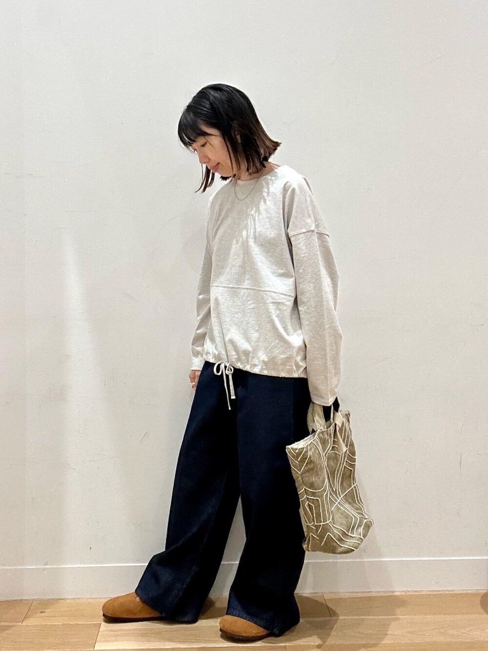 ベージュ系のTシャツ/カットソー、ブルー系のデニムパンツ、ブラウン系のその他シューズを着用したレディースの秋コーディネートの6枚目の写真