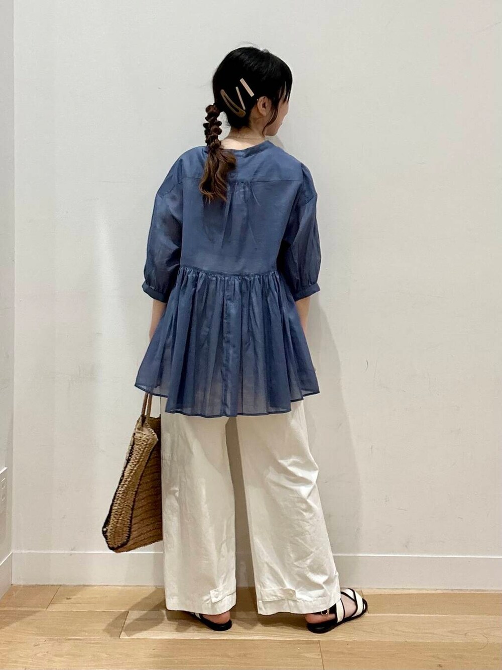 ベージュ系のトートバッグ、ホワイト系のサンダル、ベージュ系のタンクトップを着用したレディースの春コーディネートの2枚目の写真