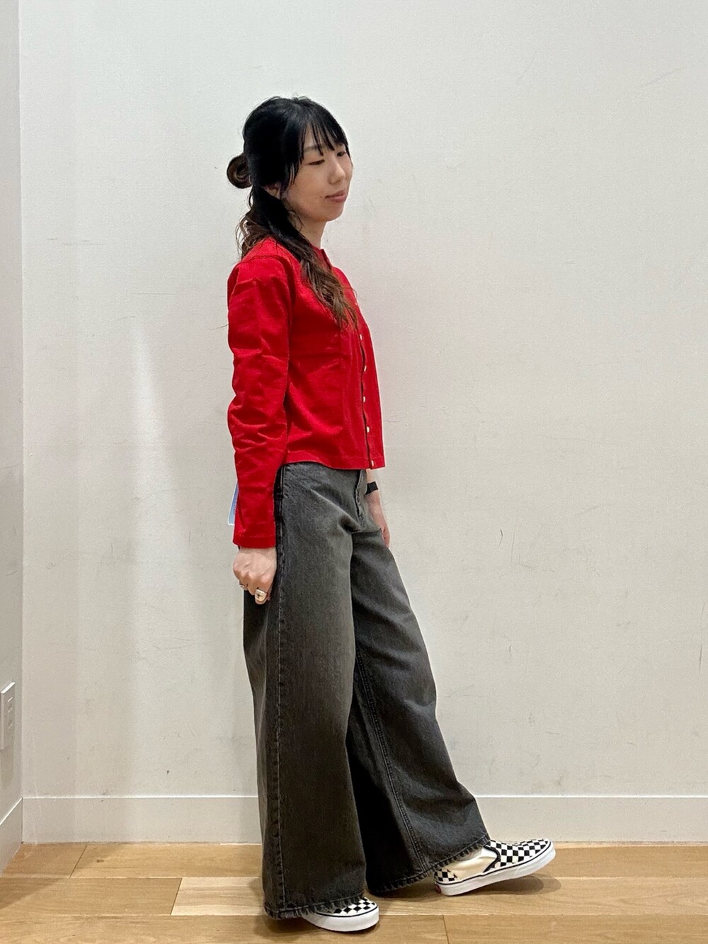 レッド系のカーディガン/ボレロ、ブラック系のデニムパンツ、シルバー系のボストンバッグを着用したレディースの夏コーディネートの3枚目の写真