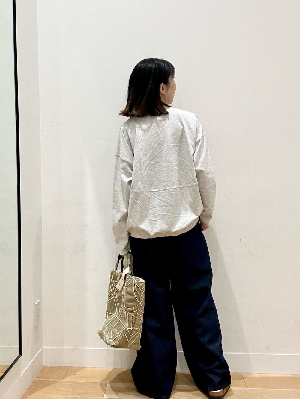 ベージュ系のTシャツ/カットソー、ブルー系のデニムパンツ、ブラウン系のその他シューズを着用したレディースの秋コーディネートの4枚目の写真