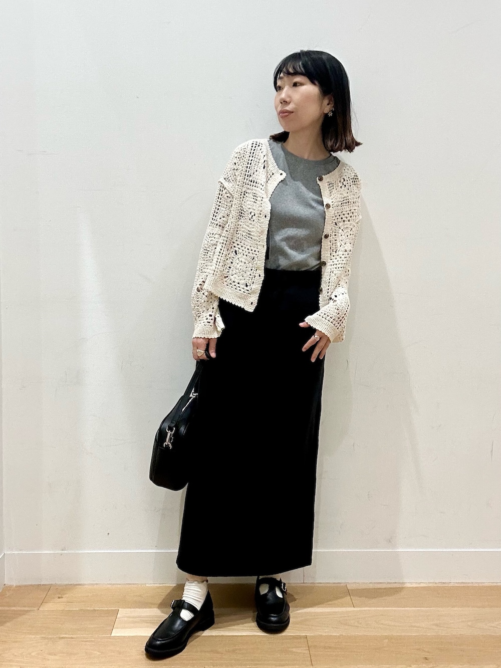 ベージュ系のカーディガン/ボレロ、グレー系のTシャツ/カットソー、ブラック系のショルダーバッグを着用したレディースの秋コーディネートの2枚目の写真