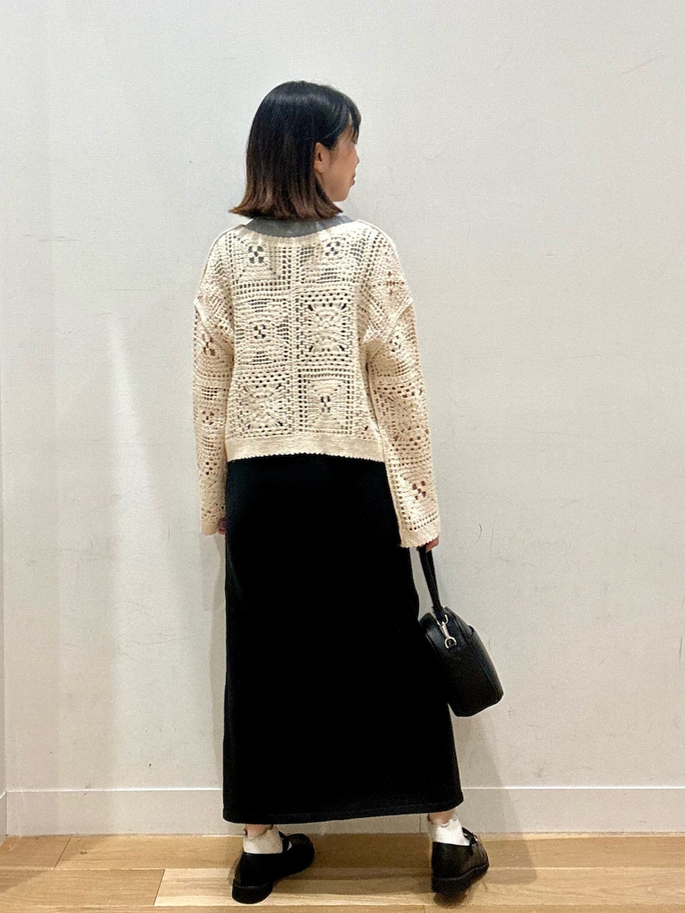 ベージュ系のカーディガン/ボレロ、グレー系のTシャツ/カットソー、ブラック系のショルダーバッグを着用したレディースの秋コーディネートの4枚目の写真