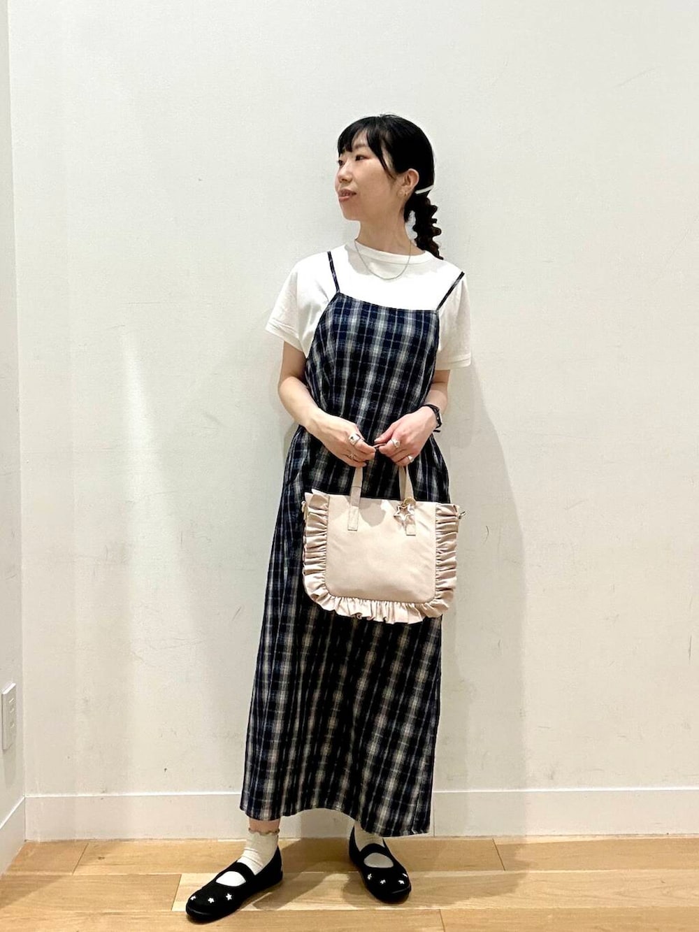 ブラック系のスニーカー、ホワイト系のTシャツ/カットソー、ホワイト系のトートバッグを着用したレディースの夏コーディネートの2枚目の写真