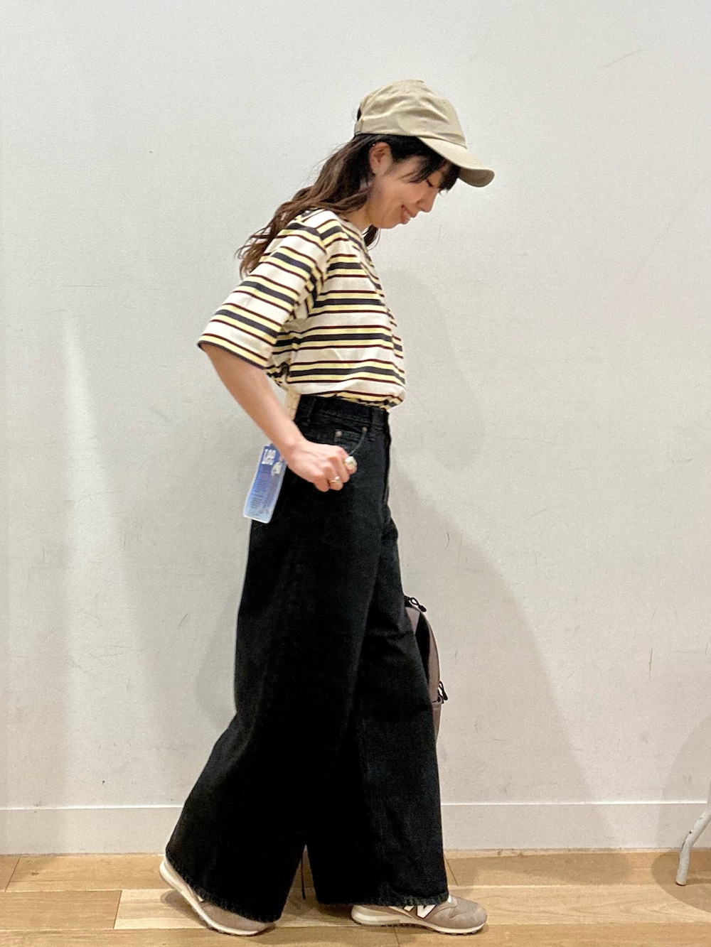 ホワイト系のTシャツ/カットソー、ブラック系のデニムパンツ、ブラウン系のバックパック/リュックを着用したレディースの夏コーディネートの2枚目の写真