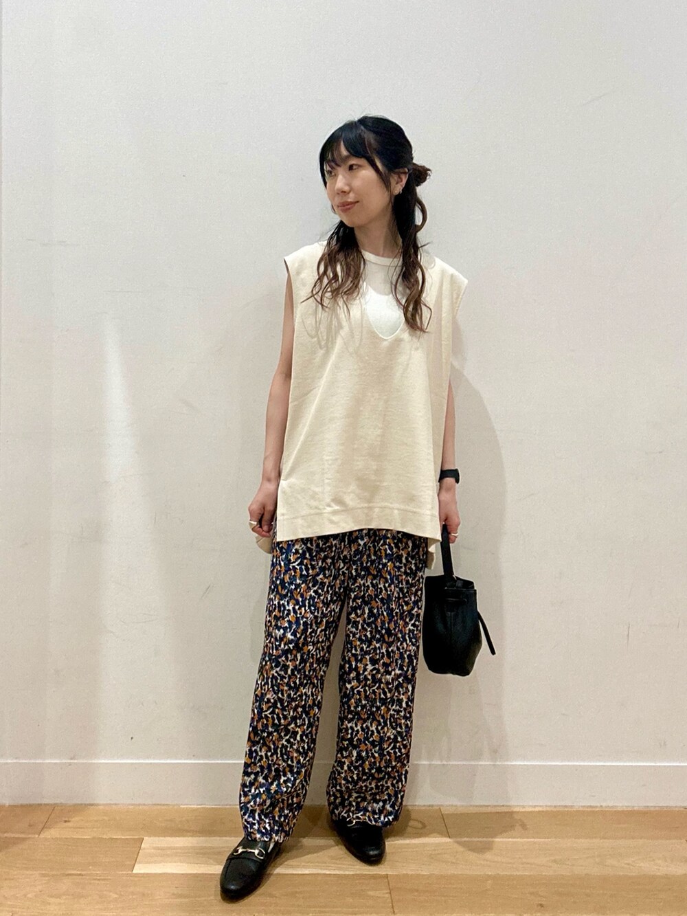 ホワイト系のTシャツ/カットソー、ホワイト系のベスト、ブラック系のパンプスを着用したレディースの夏コーディネートの2枚目の写真