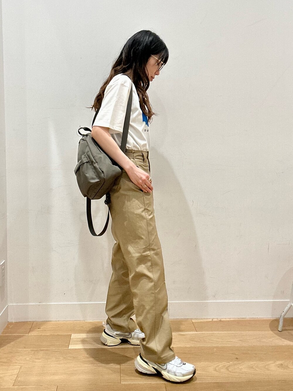 ベージュ系のその他パンツ、シルバー系のスニーカー、グリーン系のバックパック/リュックを着用したレディースの夏コーディネートの2枚目の写真