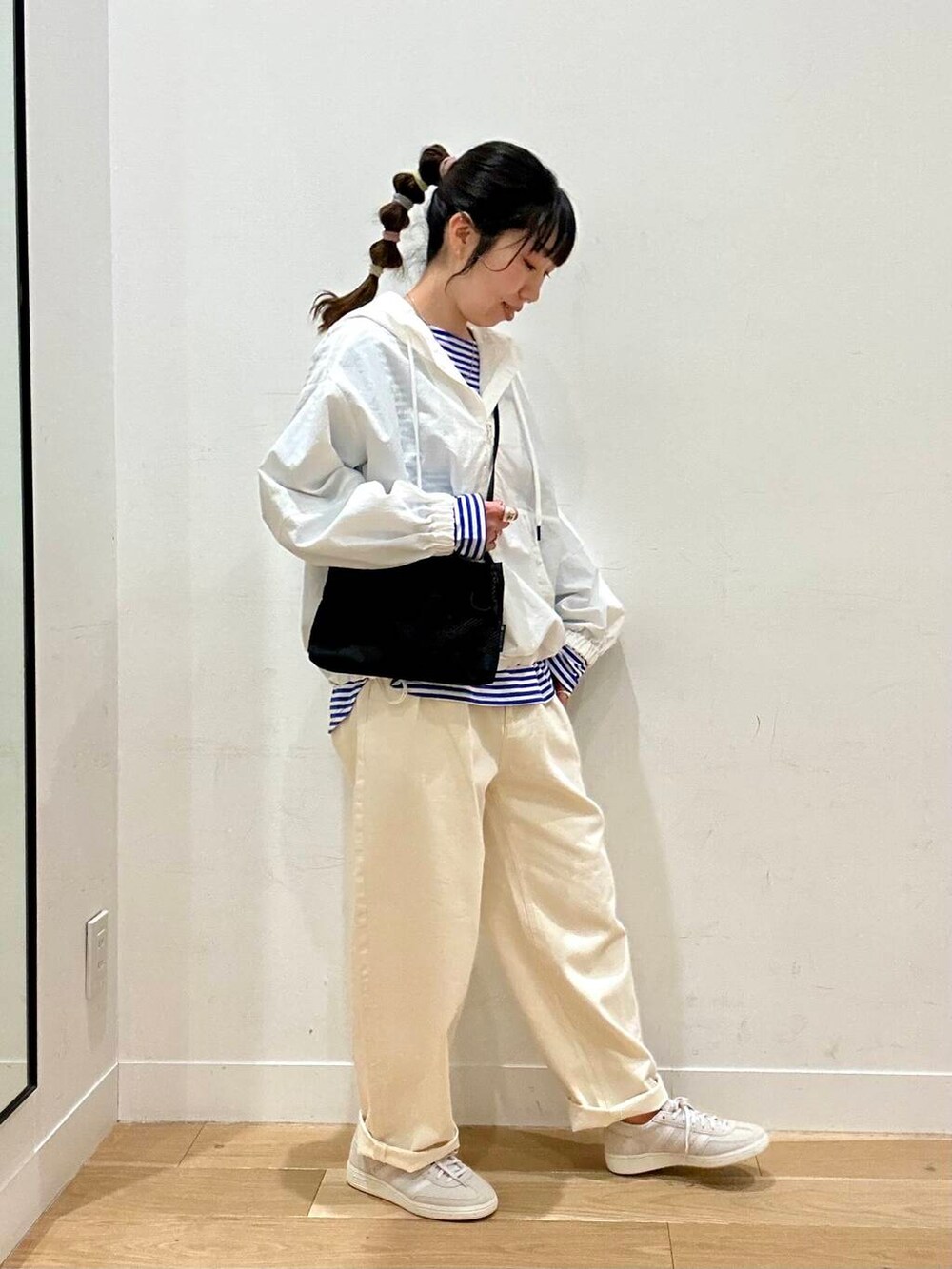 ホワイト系のデニムパンツ、ホワイト系のパーカー、ブルー系のTシャツ/カットソーを着用したレディースの春コーディネートの2枚目の写真