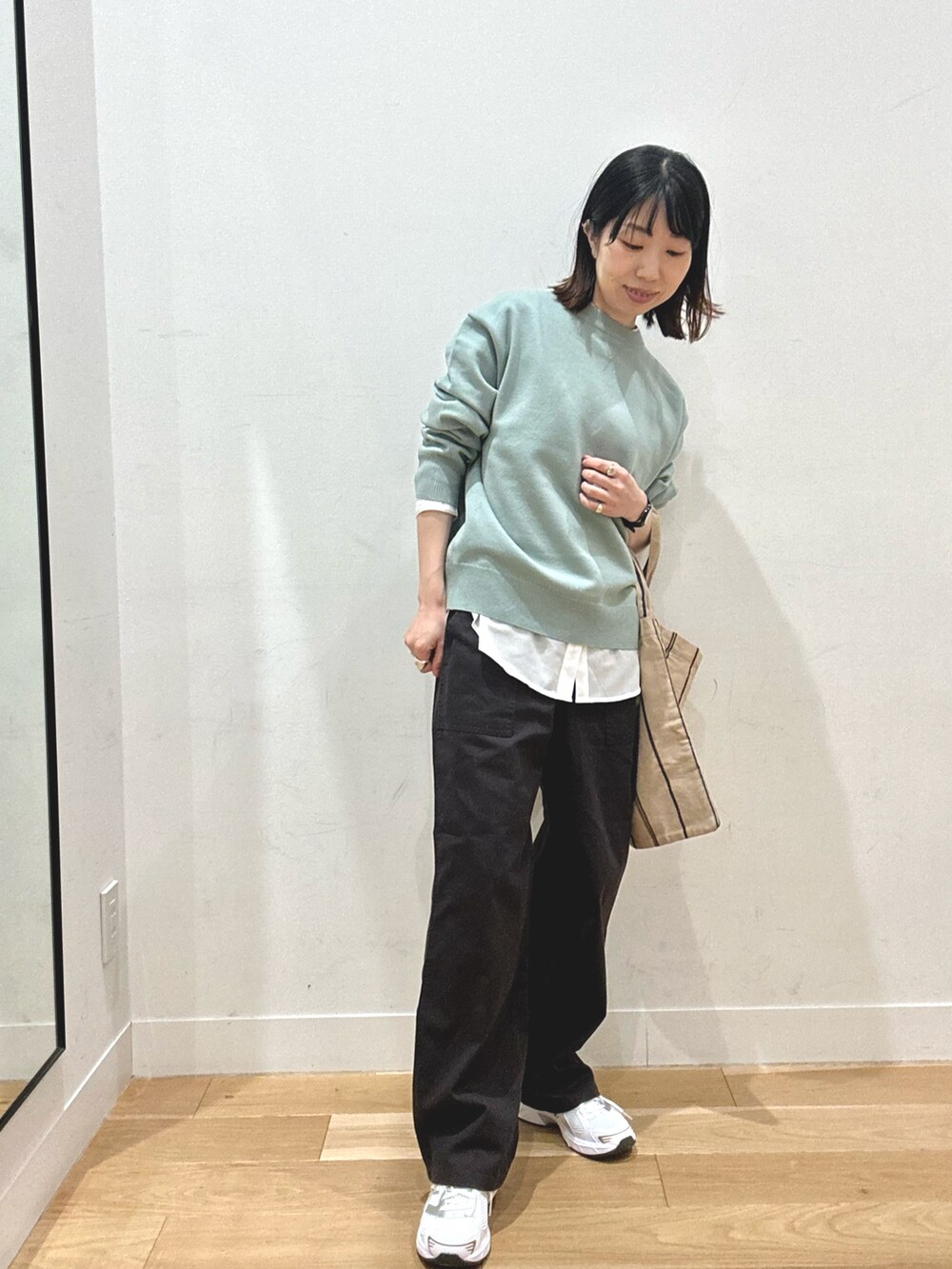 ホワイト系のシャツ/ブラウス、グレー系のパンツ、ホワイト系のスニーカーを着用したレディースの秋コーディネートの2枚目の写真