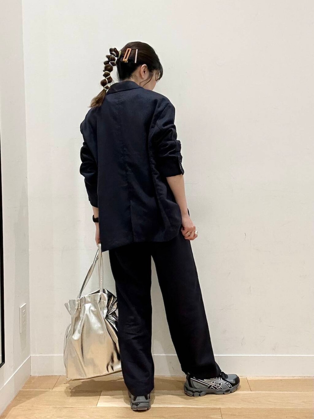 シルバー系のトートバッグ、ブラック系のスニーカーを着用したレディースの春コーディネートの2枚目の写真