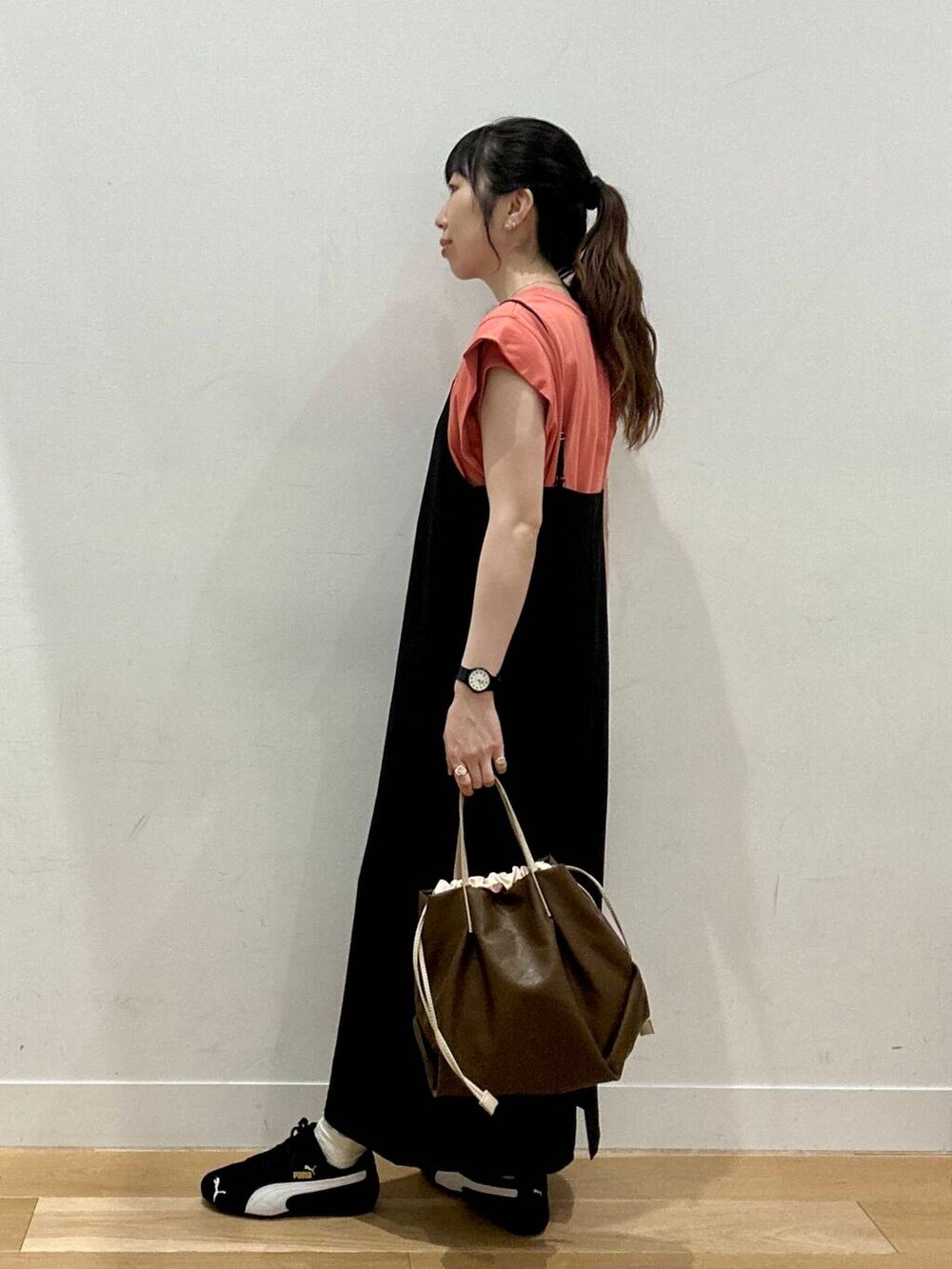 ブラック系のスニーカー、ブラウン系のTシャツ/カットソー、ブラック系のワンピースを着用したレディースの夏コーディネートの3枚目の写真