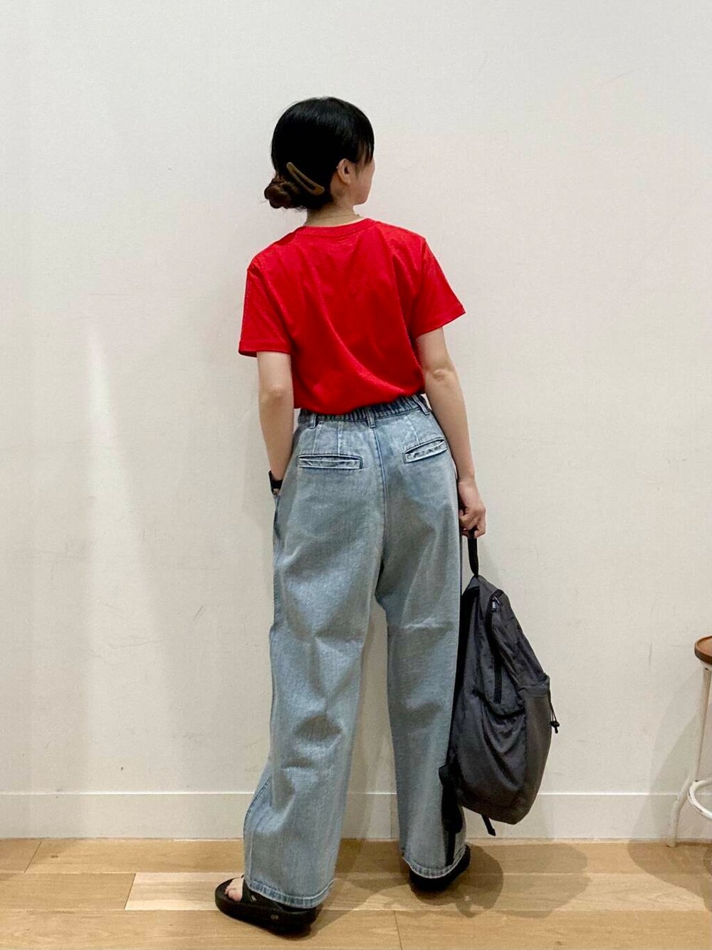 ブルー系のデニムパンツ、グレー系のバックパック/リュック、ブラック系のサンダルを着用したレディースの夏コーディネートの3枚目の写真