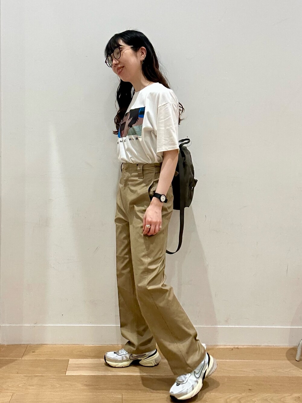 ベージュ系のその他パンツ、シルバー系のスニーカー、グリーン系のバックパック/リュックを着用したレディースの夏コーディネートの3枚目の写真