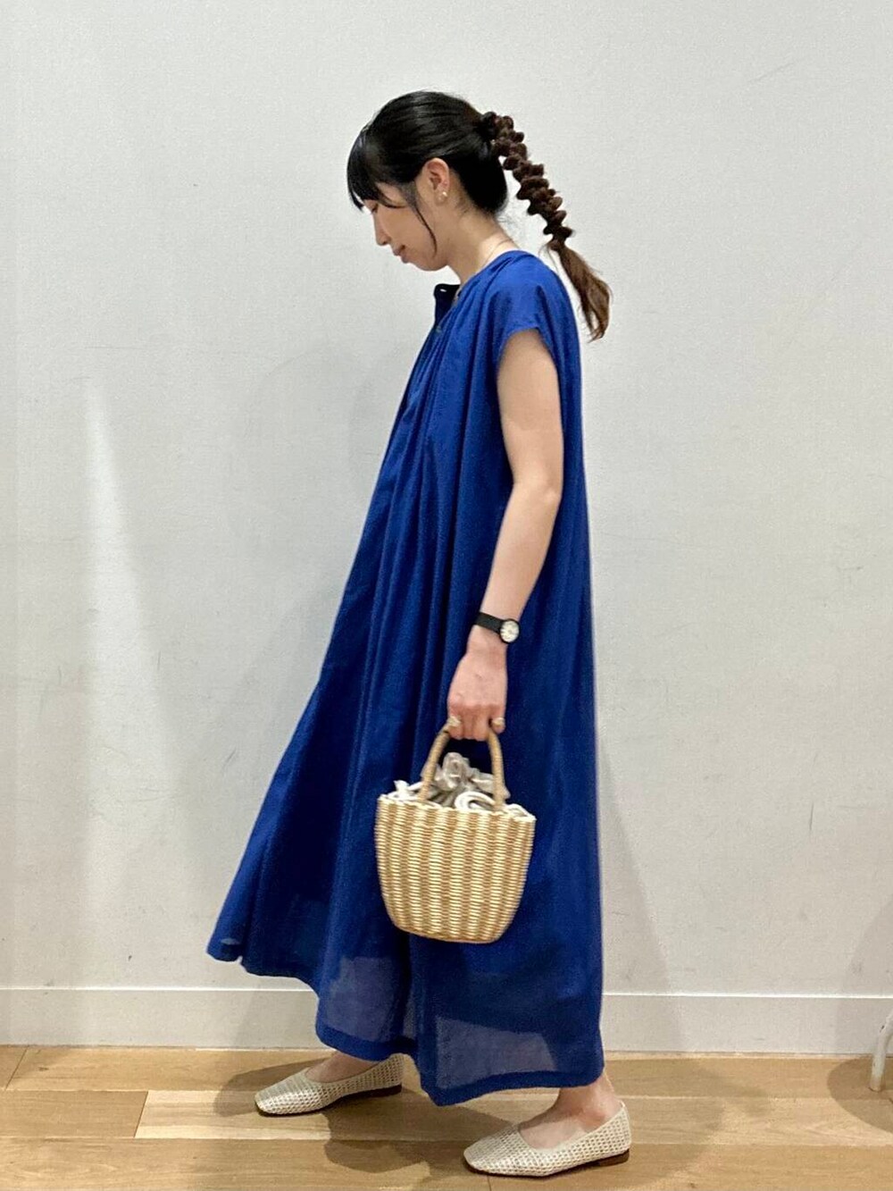 グレー系のハンドバッグ、ホワイト系のバレエシューズ、ブルー系のワンピースを着用したレディースの夏コーディネートの3枚目の写真