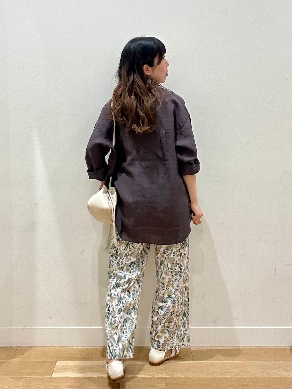 ホワイト系のショルダーバッグ、ホワイト系のサンダル、ベージュ系のその他パンツを着用したレディースの夏コーディネートの2枚目の写真