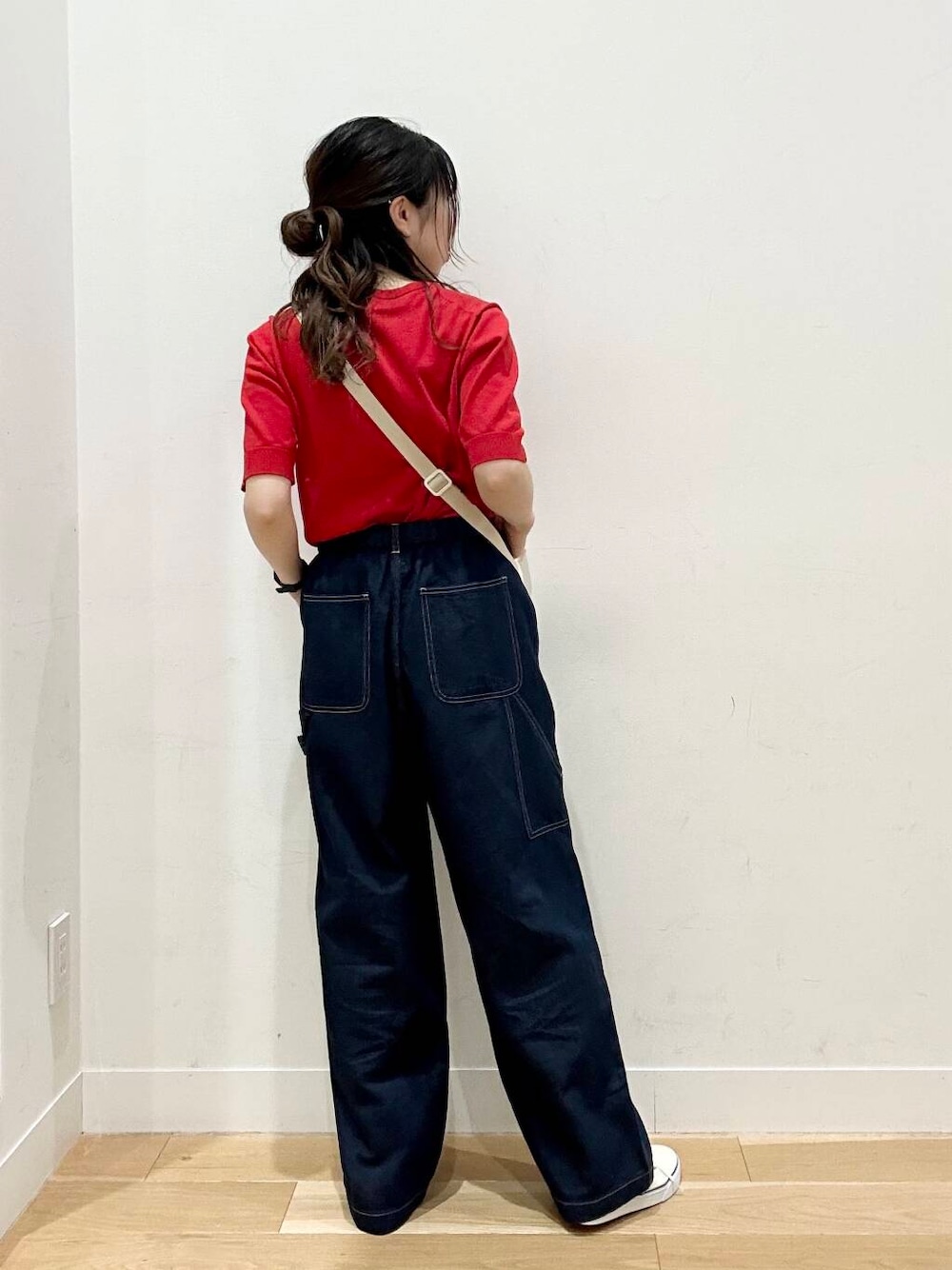 ブルー系のデニムパンツ、レッド系のニット/セーターを着用したレディースの春コーディネートの3枚目の写真