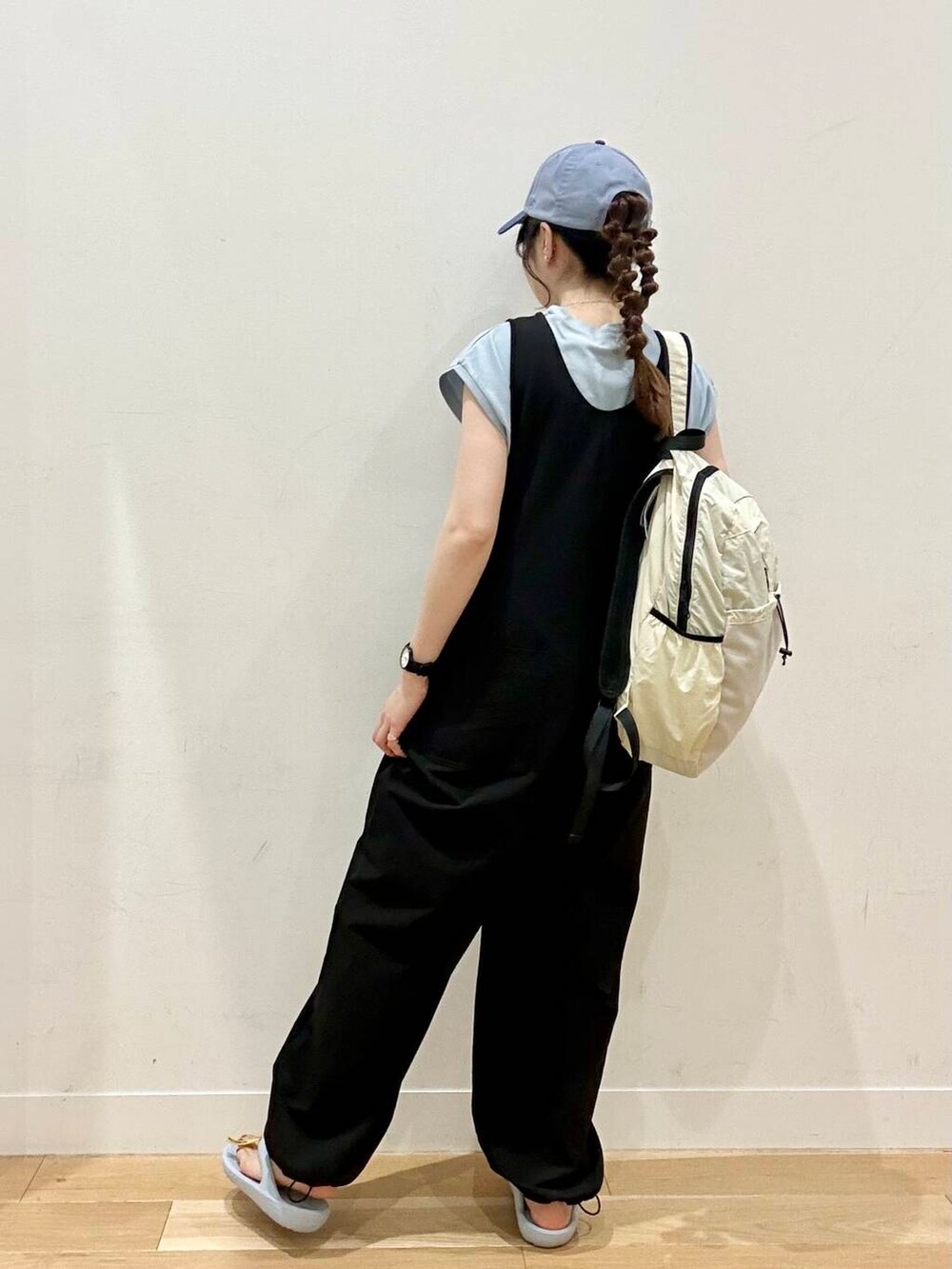 ブラック系のワンピース、ホワイト系のバックパック/リュック、ブルー系のサンダルを着用したレディースの夏コーディネートの5枚目の写真