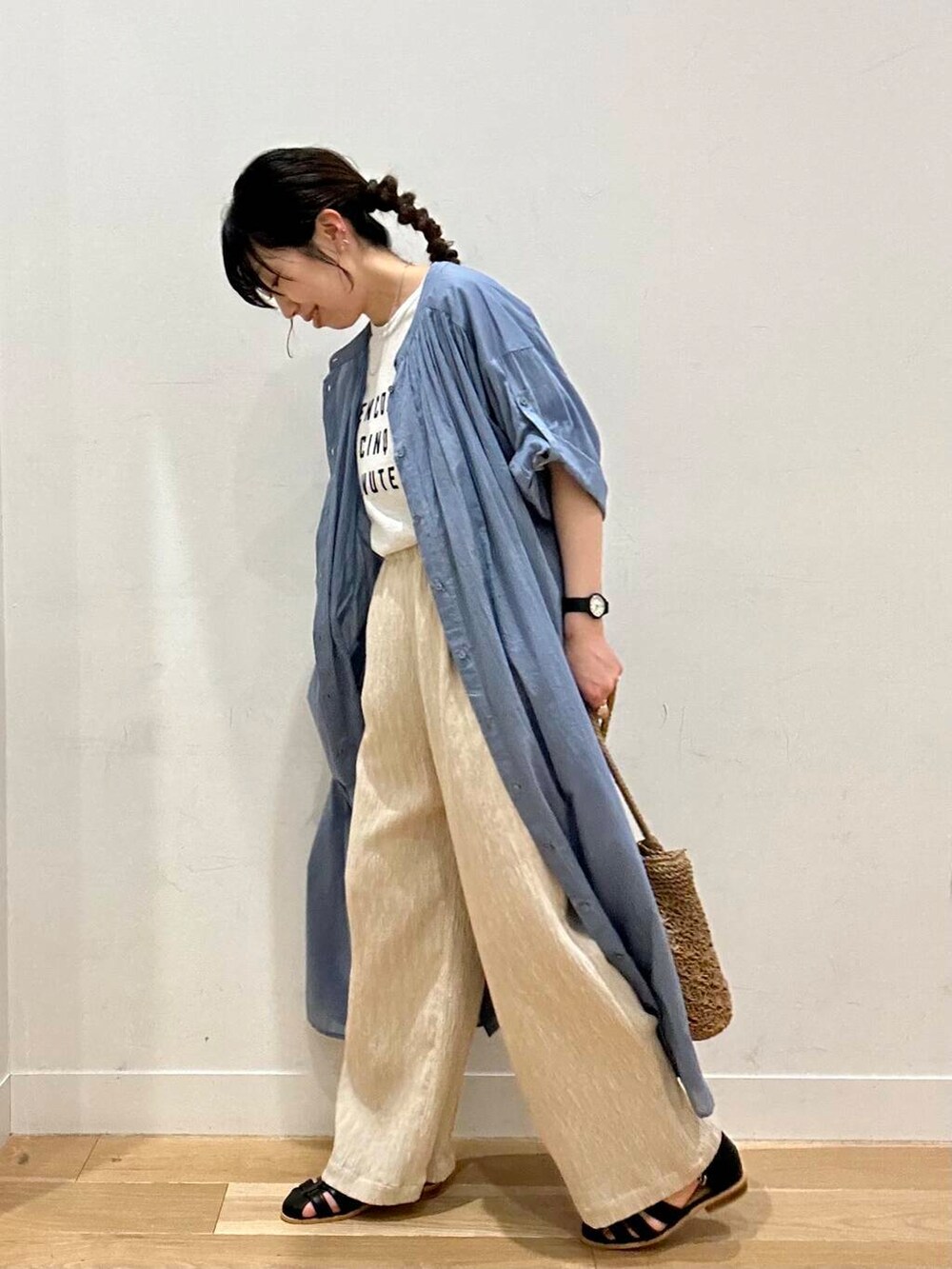 ブラック系のサンダル、ベージュ系のトートバッグ、ブルー系のワンピースを着用したレディースの春コーディネートの4枚目の写真