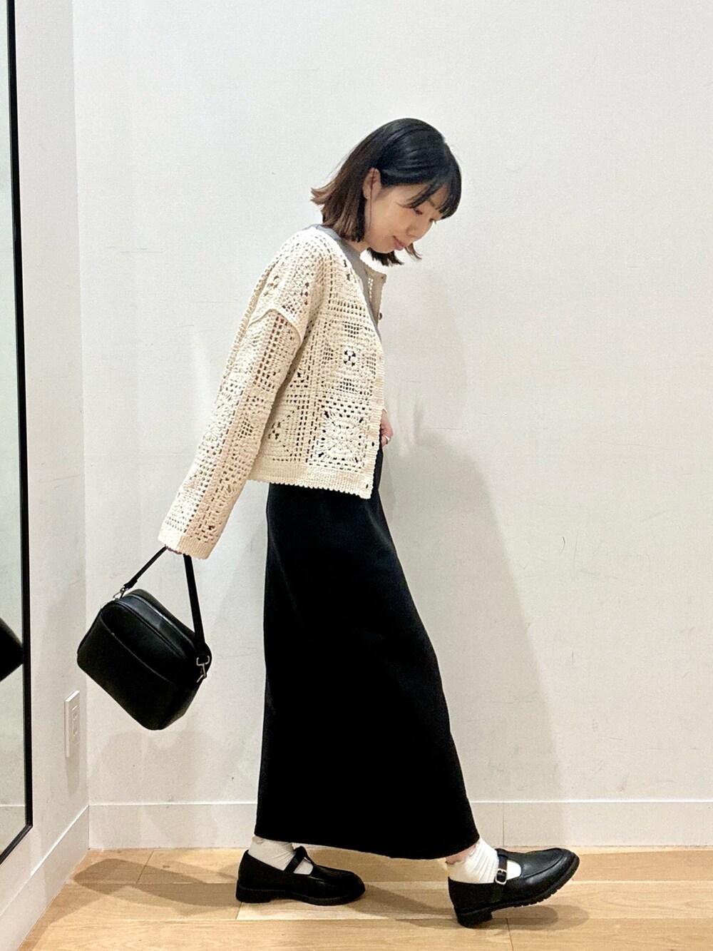 ベージュ系のカーディガン/ボレロ、グレー系のTシャツ/カットソー、ブラック系のショルダーバッグを着用したレディースの秋コーディネートの5枚目の写真