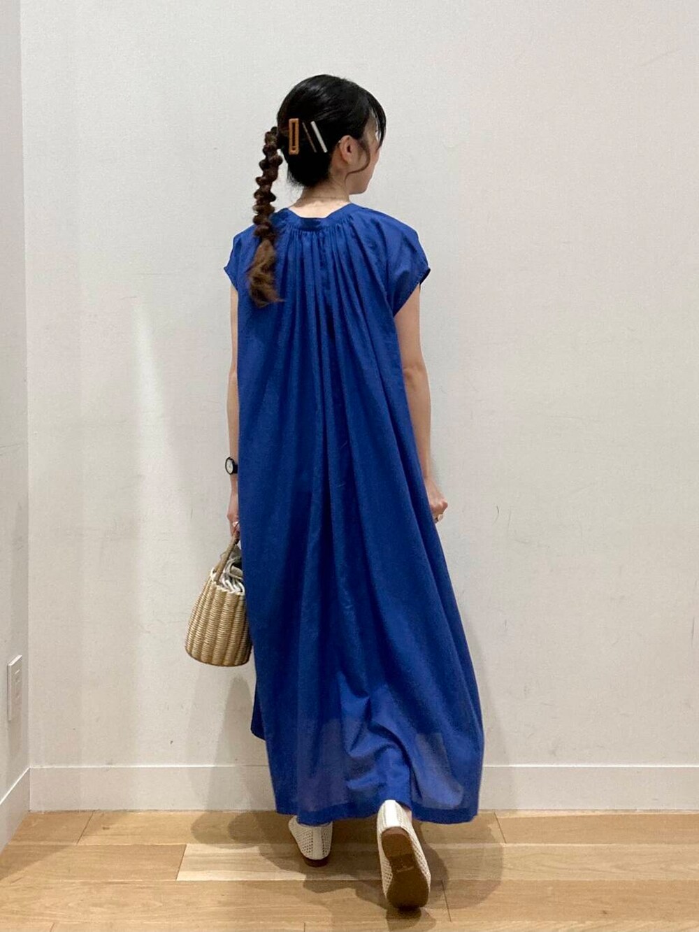 グレー系のハンドバッグ、ホワイト系のバレエシューズ、ブルー系のワンピースを着用したレディースの夏コーディネートの2枚目の写真