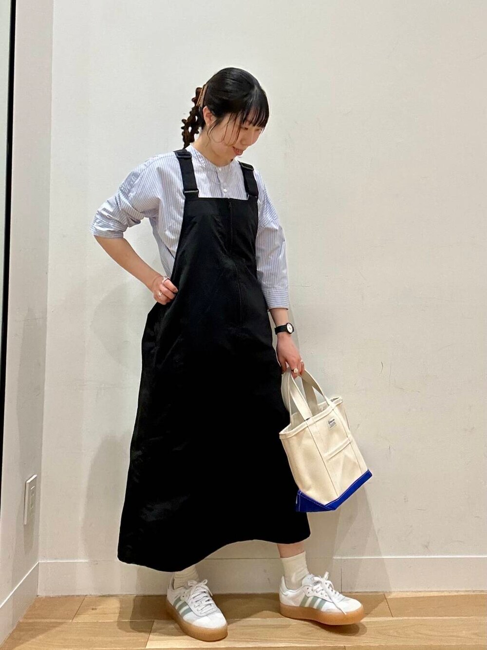 ブルー系のシャツ/ブラウス、ブラック系のワンピース、ブラック系のアナログ腕時計を着用したレディースの春コーディネートの2枚目の写真