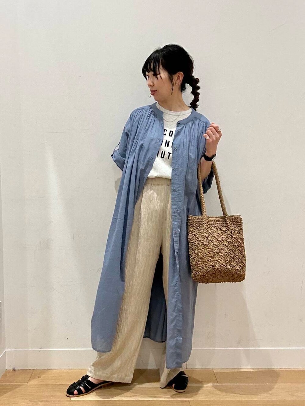 ブラック系のサンダル、ベージュ系のトートバッグ、ブルー系のワンピースを着用したレディースの春コーディネートの2枚目の写真