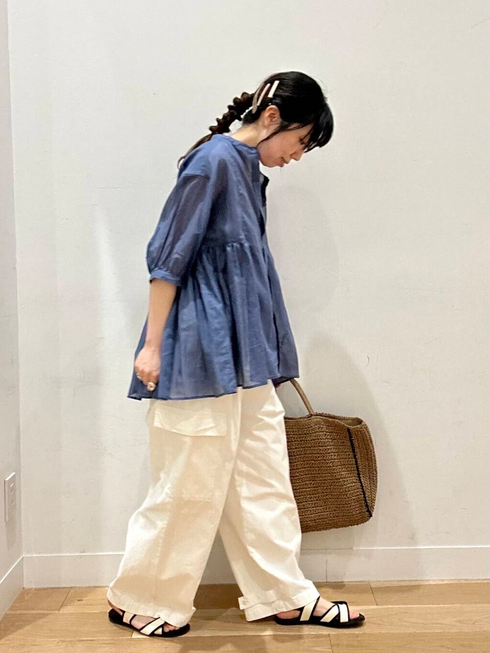 ベージュ系のトートバッグ、ホワイト系のサンダル、ベージュ系のタンクトップを着用したレディースの春コーディネートの3枚目の写真