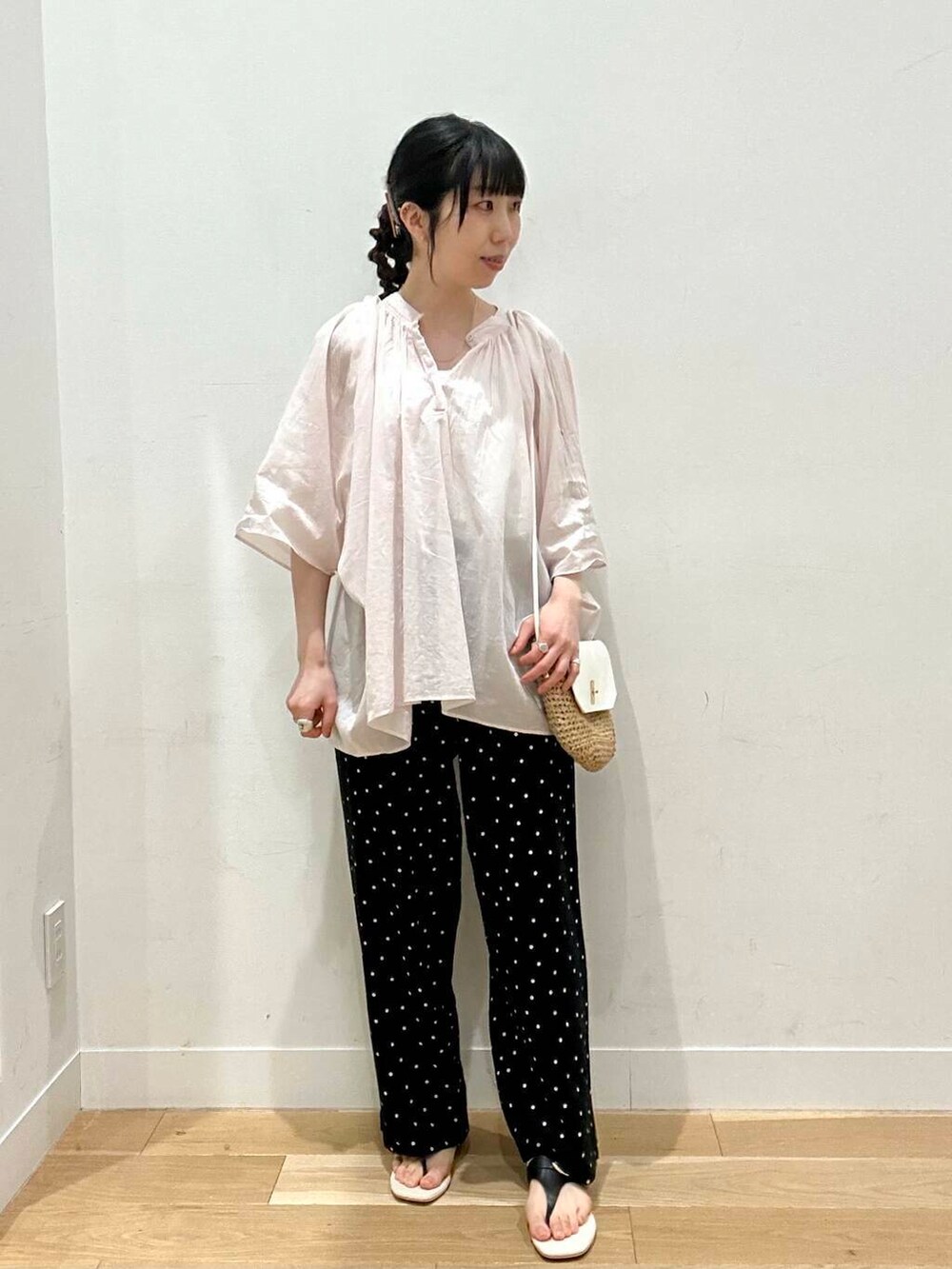 イエロー系のショルダーバッグ、ホワイト系のタンクトップ、ブラック系のその他パンツを着用したレディースの夏コーディネートの4枚目の写真