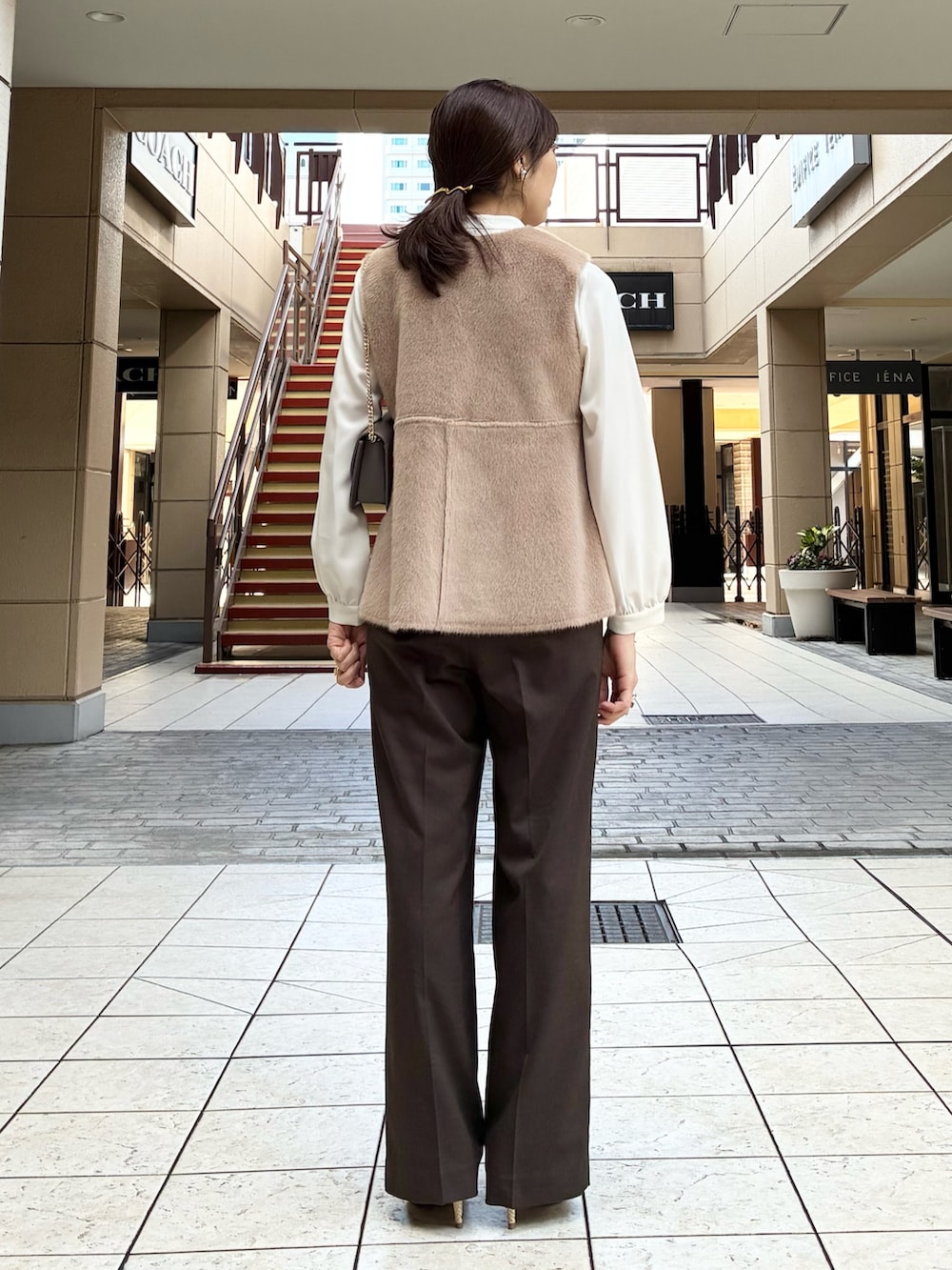 ブラウン系のその他パンツ、イエロー系のブルゾン、ホワイト系のシャツ/ブラウスを着用したレディースの秋コーディネートの3枚目の写真