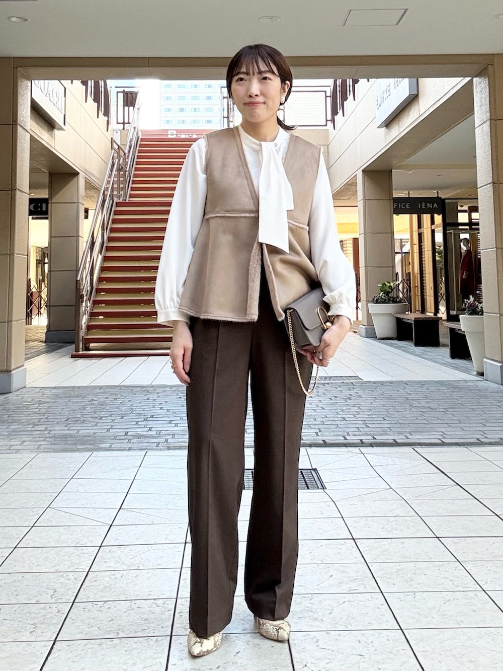 ブラウン系のその他パンツ、イエロー系のブルゾン、ホワイト系のシャツ/ブラウスを着用したレディースの秋コーディネートの9枚目の写真