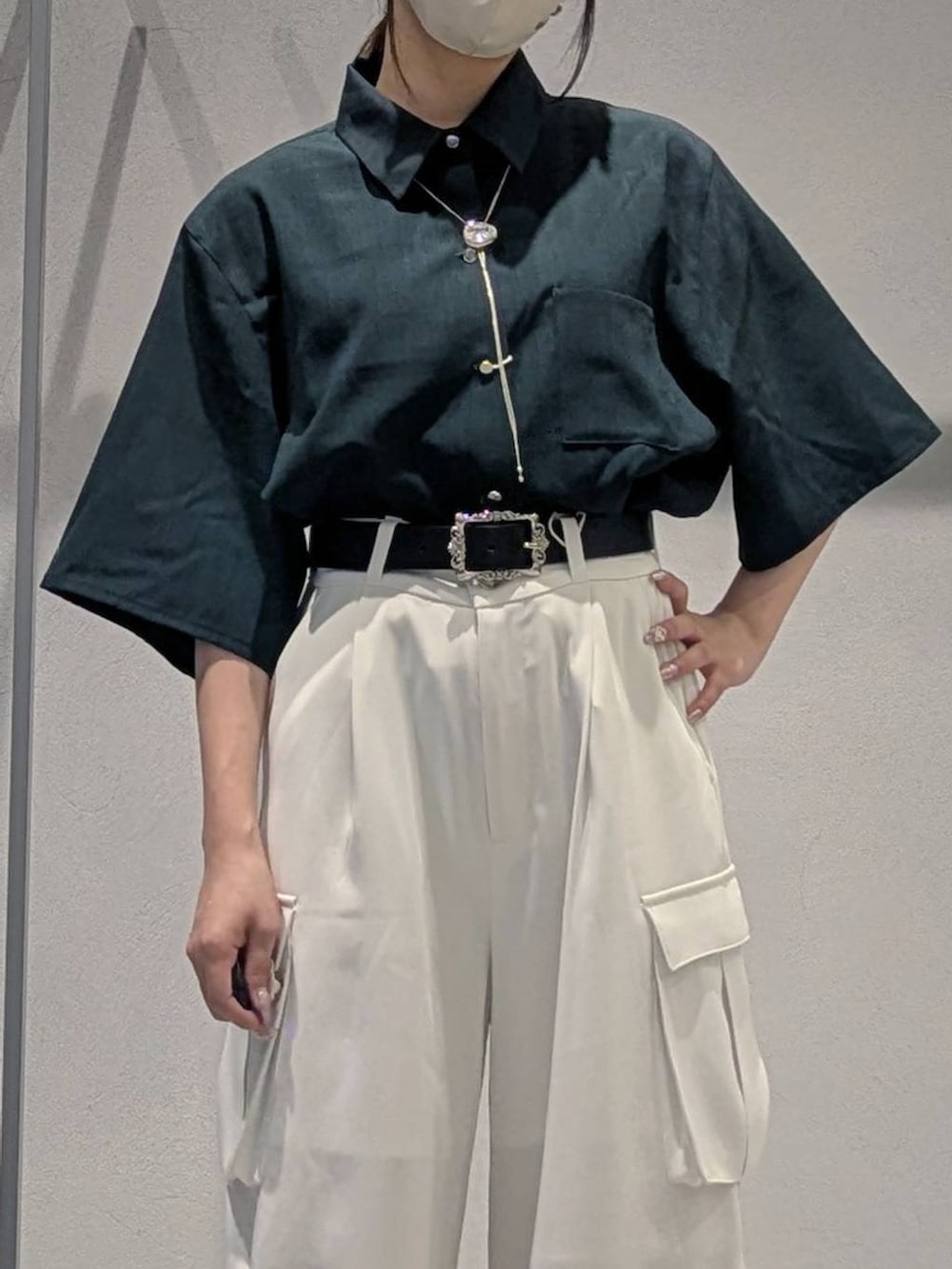 ホワイト系のカーゴパンツ、ブラック系のサンダル、グリーン系のシャツ/ブラウスを着用したレディースの夏コーディネートの2枚目の写真