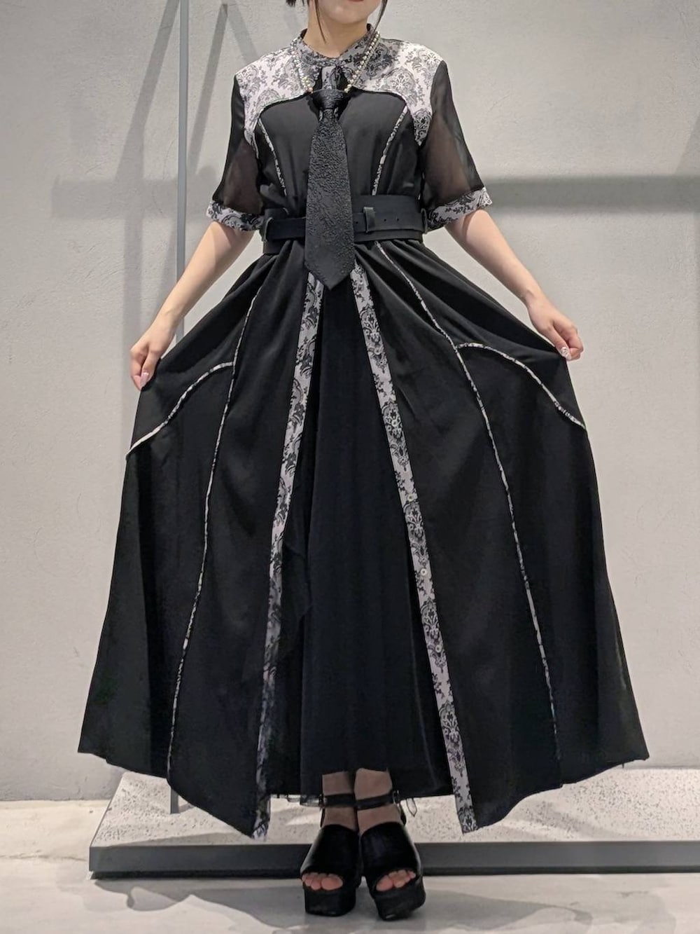 ブラック系のネクタイ、ブラック系のサンダル、ブラック系のワンピースを着用したレディースの夏コーディネートの5枚目の写真