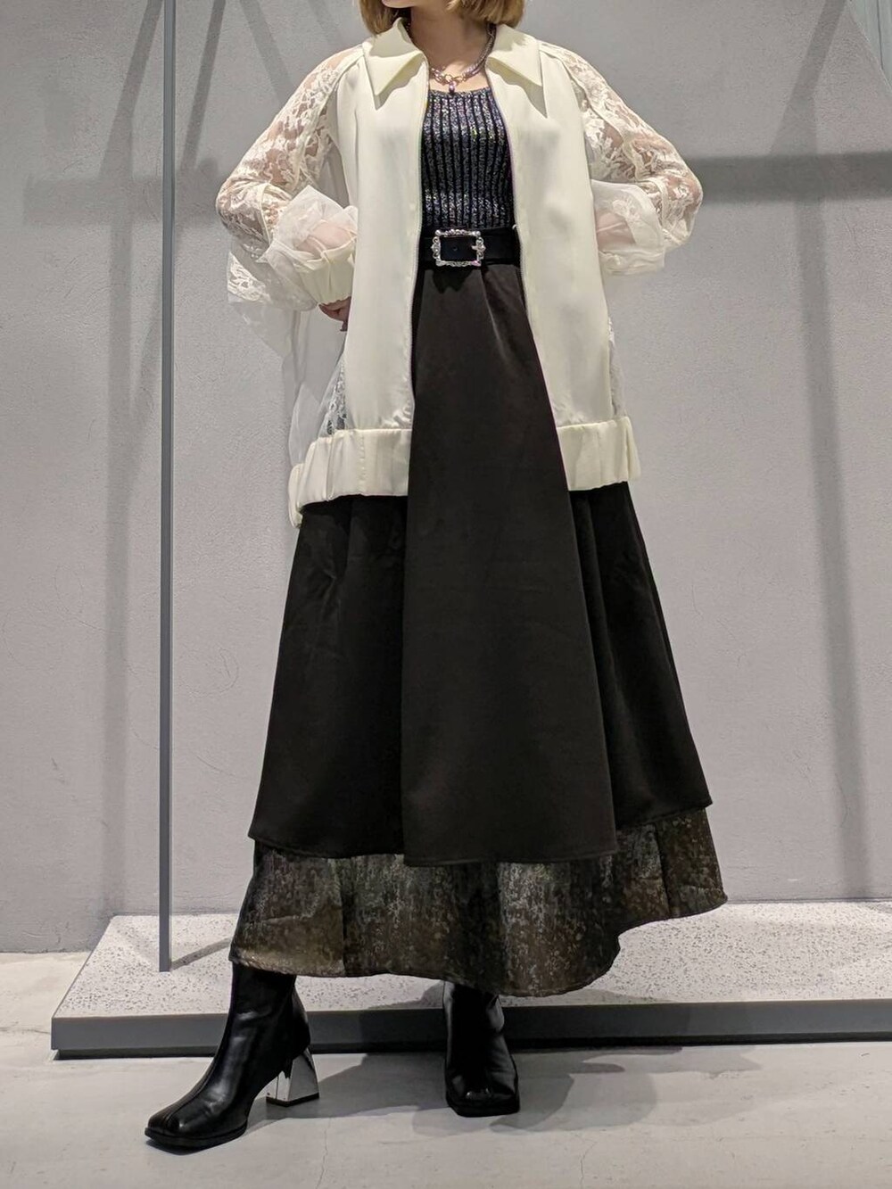 ブラック系のタンクトップ、ホワイト系のブルゾン、ブラック系のブーツを着用したレディースの夏コーディネートの4枚目の写真