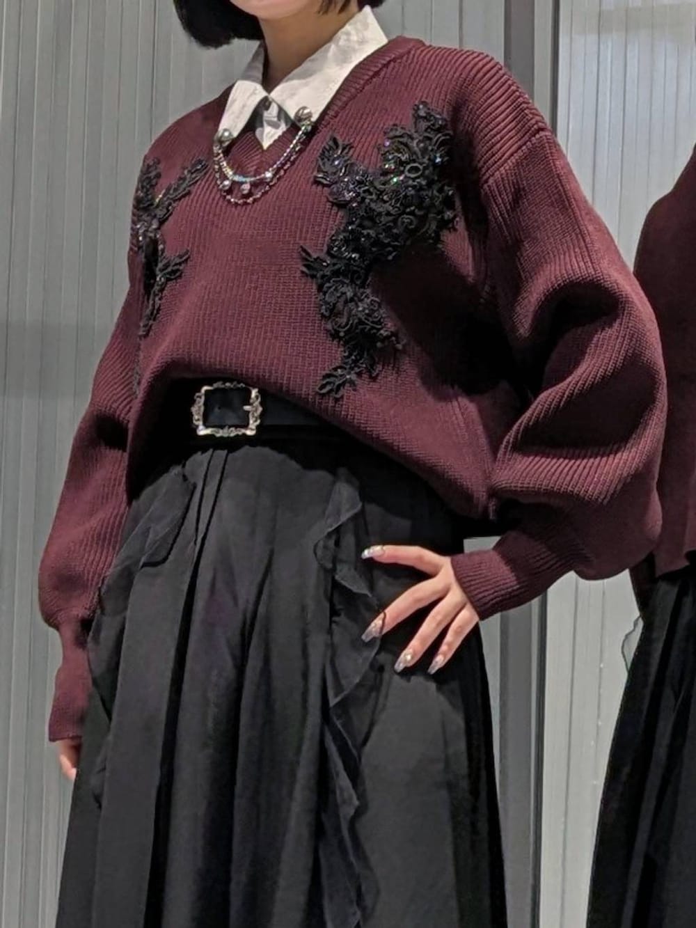 ブラック系のスカート、グレー系のブーツ、レッド系のニット/セーターを着用したレディースの秋コーディネートの2枚目の写真