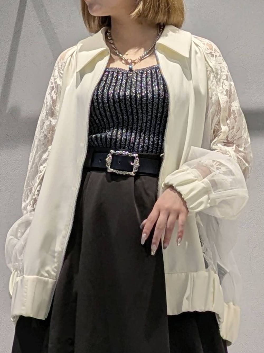 ブラック系のタンクトップ、ホワイト系のブルゾン、ブラック系のブーツを着用したレディースの夏コーディネートの2枚目の写真